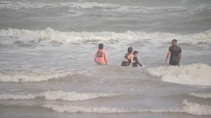 photograph of people swiming in Galveston beach.