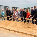 photograph of people holding shovels to break ground on health clinic