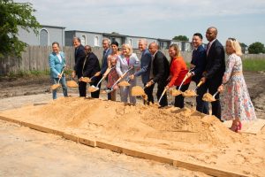 photograph of people holding shovels to break ground on health clinic