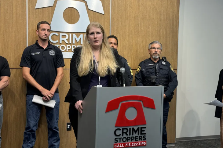 woman stands behind podium at an indoor press conference.